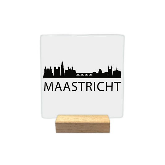 Maastricht skyline - Decoratie tegel - Formaat: - Op deze decoratie tegel staat een zwarte skyline van Maastricht afgebeeld tegen een witte achtergrond. Het silhouet toont kenmerkende gebouwen uit de stad, zoals een brug en verschillende torens. Onder de skyline staat in zwarte letters de naam Maastricht. Het ontwerp is minimalistisch uitgevoerd in zwart en wit. - Snelwenskaart