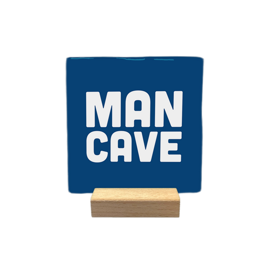 Man cave - Decoratie tegel - Formaat: - Op deze decoratietegel staat de tekst "MAN CAVE" in witte, robuuste hoofdletters. De tekst is gecentreerd op een donkerblauwe, vierkante achtergrond. - Snelwenskaart