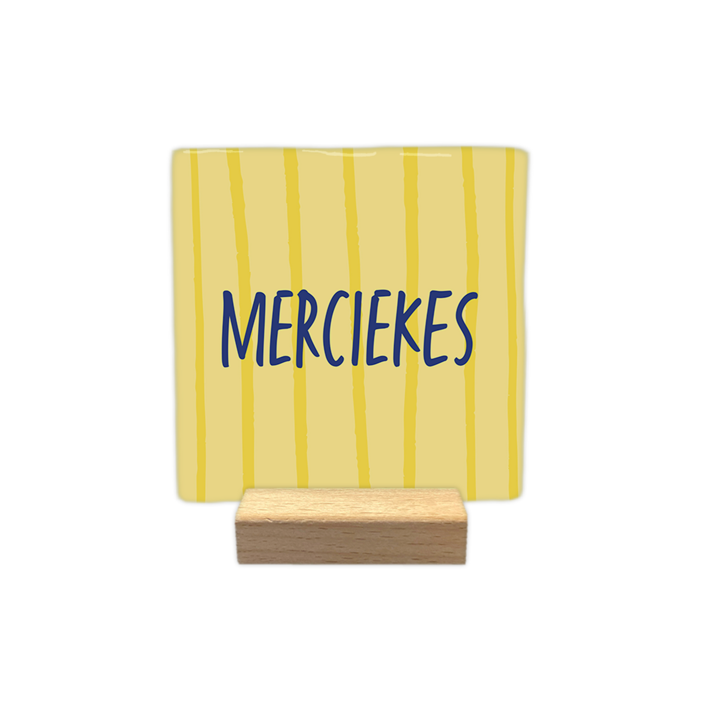 Merciekes - Decoratie tegel - Formaat: - Op deze decoratie tegel staat de tekst "merciekes" in blauwe, handgeschreven letters. De achtergrond van de tegel is lichtgeel en is voorzien van verticale, onregelmatige lijnen in een donkerdere kleur geel. - Snelwenskaart