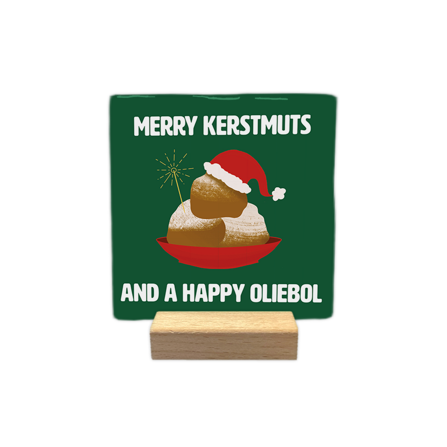 Merry kerstmuts - Decoratie tegel - Formaat: - Op deze decoratie tegel staat een groene achtergrond met een illustratie van een rode schaal met oliebollen erop. De bovenste oliebol draagt een rode kerstmuts met witte rand en er steekt een sterretje uit de schaal. Bovenaan en onderaan staat in witte letters de tekst merry kerstmuts and a happy oliebol. - Snelwenskaart