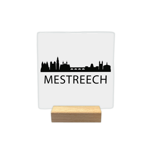 Mestreech skyline - Decoratie tegel - Formaat: - Op deze decoratie tegel staat een zwarte skyline van Maastricht afgebeeld tegen een witte achtergrond. Het silhouet toont kenmerkende gebouwen uit de stad, zoals een brug en verschillende torens. Onder de skyline staat in zwarte letters de naam Mestreech. Het ontwerp is minimalistisch uitgevoerd in zwart en wit. - Snelwenskaart