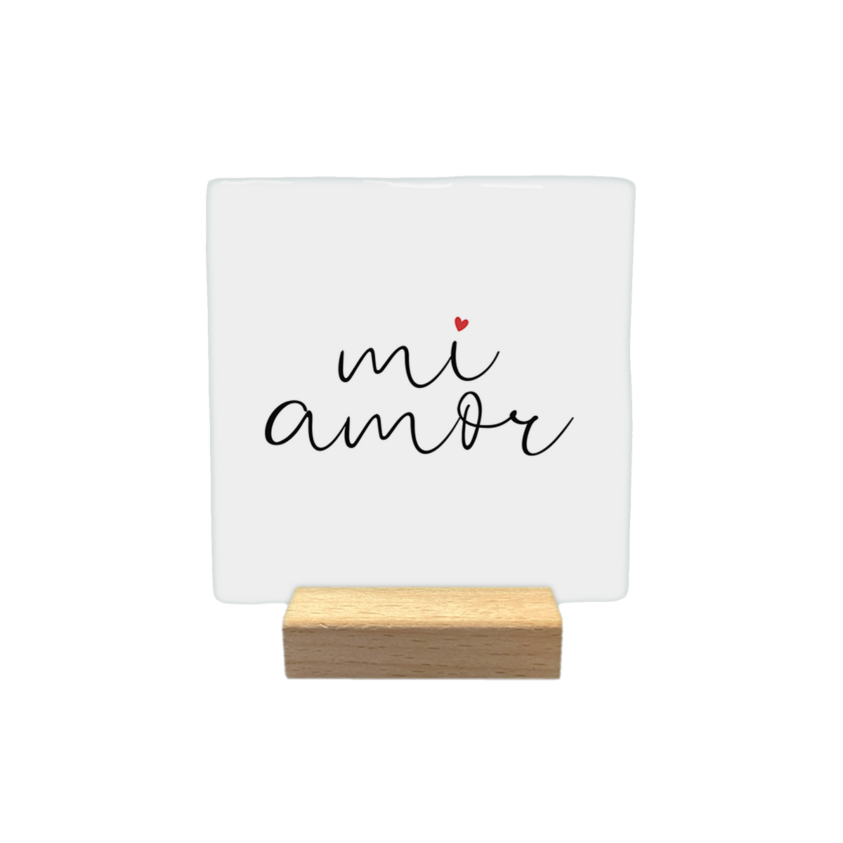 Mi amor - Decoratie tegel - Formaat: - Op deze decoratietegel staat de tekst "mi amor" in een zwart, cursief handschrift. Boven de letter "i" staat een klein, rood hartje. De tekst is gecentreerd op een witte achtergrond. - Snelwenskaart