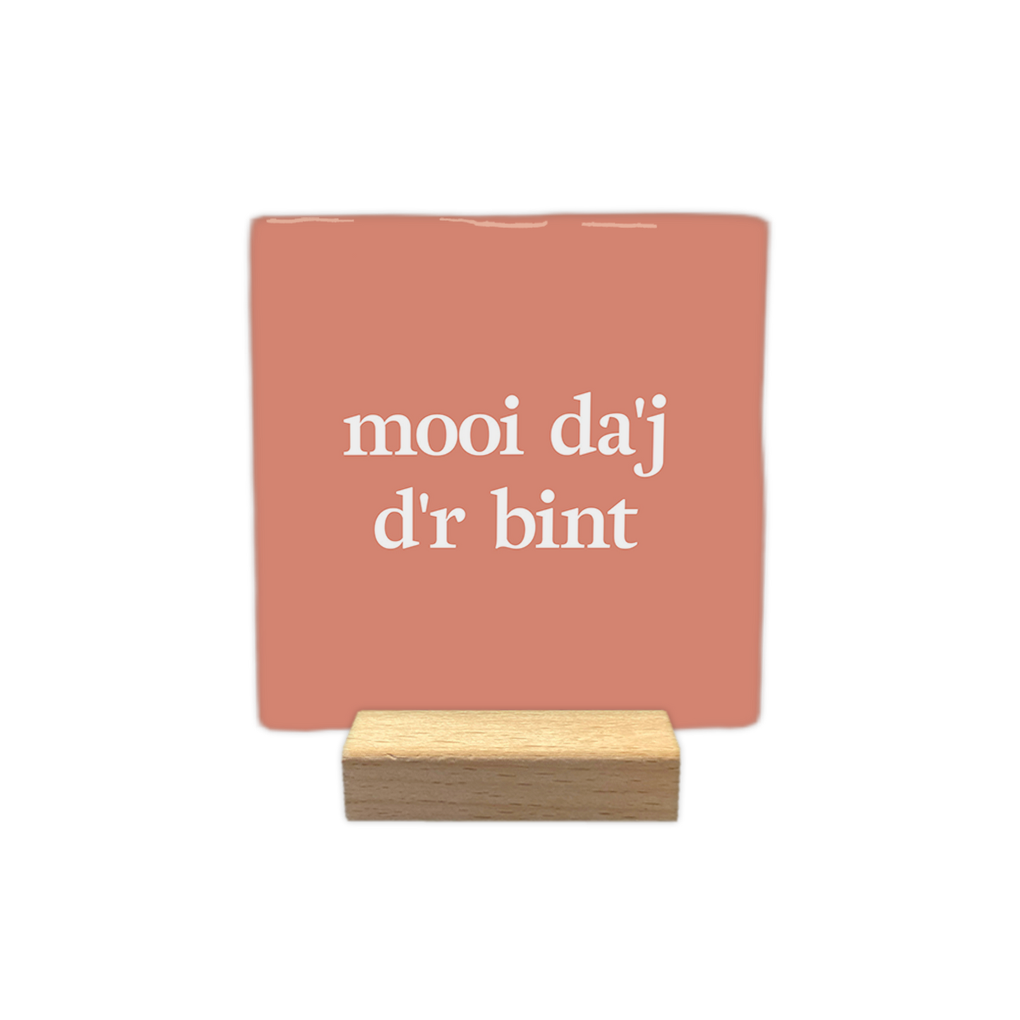 Mooi da'j d'r bint - Decoratie tegel - Formaat: - Op deze decoratie tegel staat de tekst "mooi da'j d'r bint" in witte letters verdeeld over twee regels. De achtergrond heeft een egale, zalmroze kleur. Het ontwerp is rustig en minimalistisch vormgegeven. - Snelwenskaart