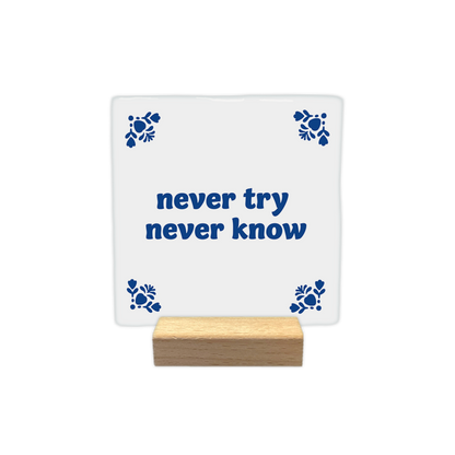 Never try never know - Decoratie tegel - Formaat: - Op deze decoratie tegel staat centraal de tekst "never try never know" in een blauw lettertype. De hoeken van de witte achtergrond zijn versierd met gestileerde, blauwe bloemmotieven. - Snelwenskaart