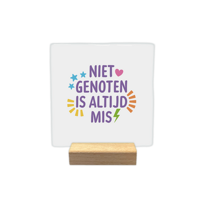 Niet genoten is altijd mis - Decoratie tegel - Formaat: - Op deze decoratie tegel staat in het paars de tekst 'Niet genoten is altijd mis'. Om de tekst heen staan verschillende vormen in verschillend kleuren. - Snelwenskaart