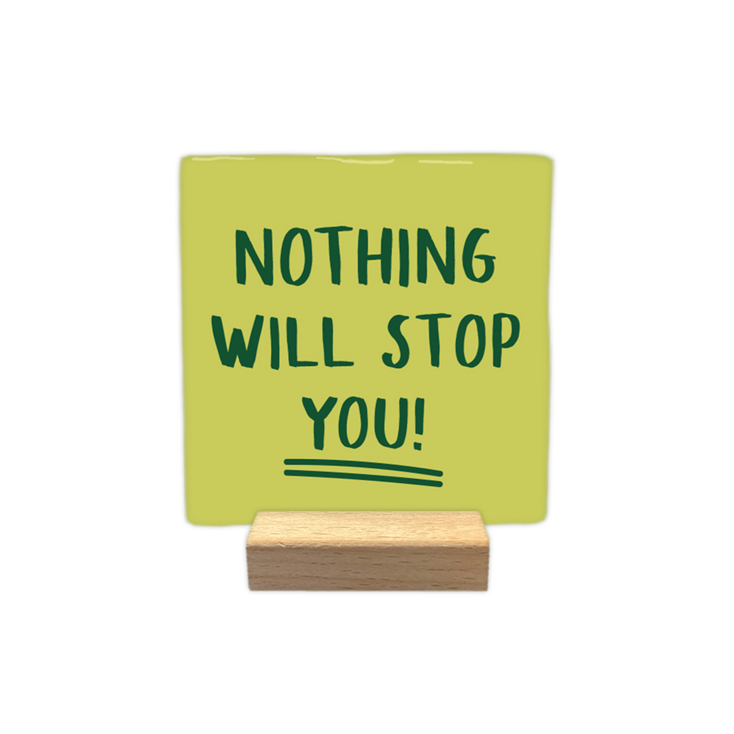 Nothing will stop you! - Decoratie tegel - Op deze wenskaart staat een vierkante, lichtgroene decoratietegel die in een houten standaard is geplaatst. Centraal op de tegel staat in donkergroene, handgeschreven hoofdletters de tekst "NOTHING WILL STOP YOU!" afgebeeld. Onder het woord "YOU!" zijn ter afsluiting twee dunne, donkergroene strepen getrokken. - Snelwenskaart