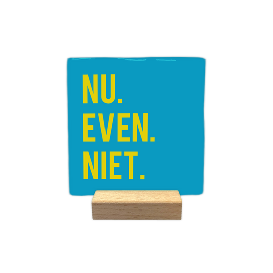 Nu even niet - Decoratie tegel - Formaat: - Op deze wenskaart is een vierkante, helderblauwe decoratietegel afgebeeld. Aan de linkerzijde van de tegel staat de tekst "NU. EVEN. NIET." geschreven in strakke, gele hoofdletters. De tekst is verdeeld over drie regels, waarbij elk woord wordt afgesloten met een duidelijke punt. - Snelwenskaart