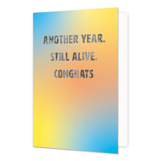 Another year. Still alive. Congrats - Formaat: Normaal - Vorm: Staand - Verjaardagskaart - Op deze wenskaart staat de tekst: "Another year. Still alive. Congrats" op een geel / blauwe achtergrond. - Snelwenskaart