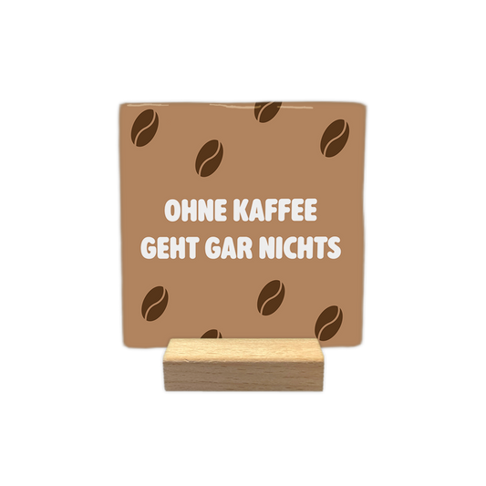 Ohne kaffee geht gar nichts - Decoratie tegel - Formaat: - Op deze decoratie tegel staat de tekst "ohne kaffee geht gar nichts" in dikke, witte letters centraal afgebeeld. De achtergrond van de tegel is lichtbruin en is voorzien van een patroon van donkerbruine koffiebonen. - Snelwenskaart