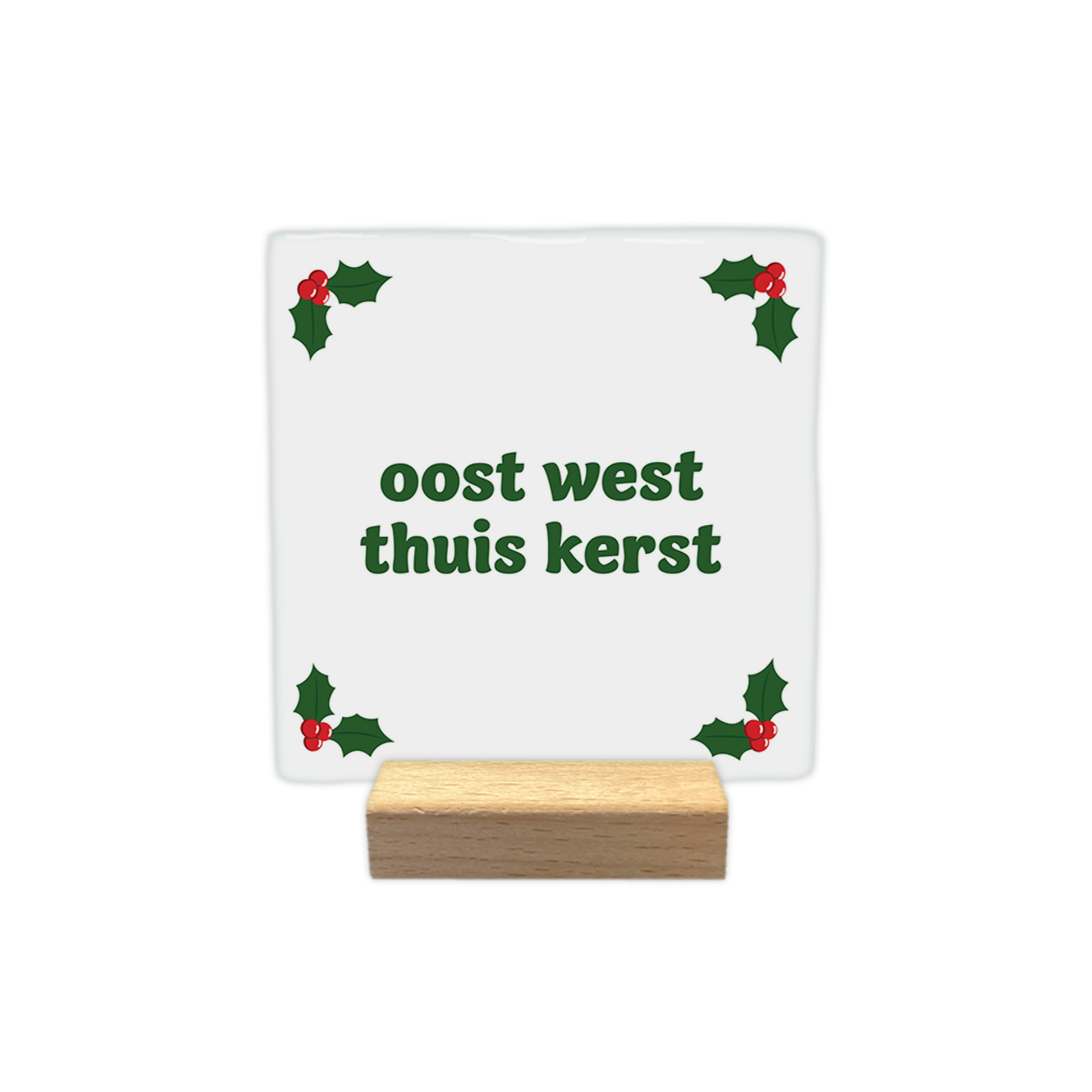 Oost west thuis kerst - Decoratie tegel - Formaat: - Op deze decoratie tegel staat een witte achtergrond met in alle vier de hoeken groene hulstblaadjes en rode bessen. In het midden staat in groene letters de tekst oost west thuis kerst. - Snelwenskaart