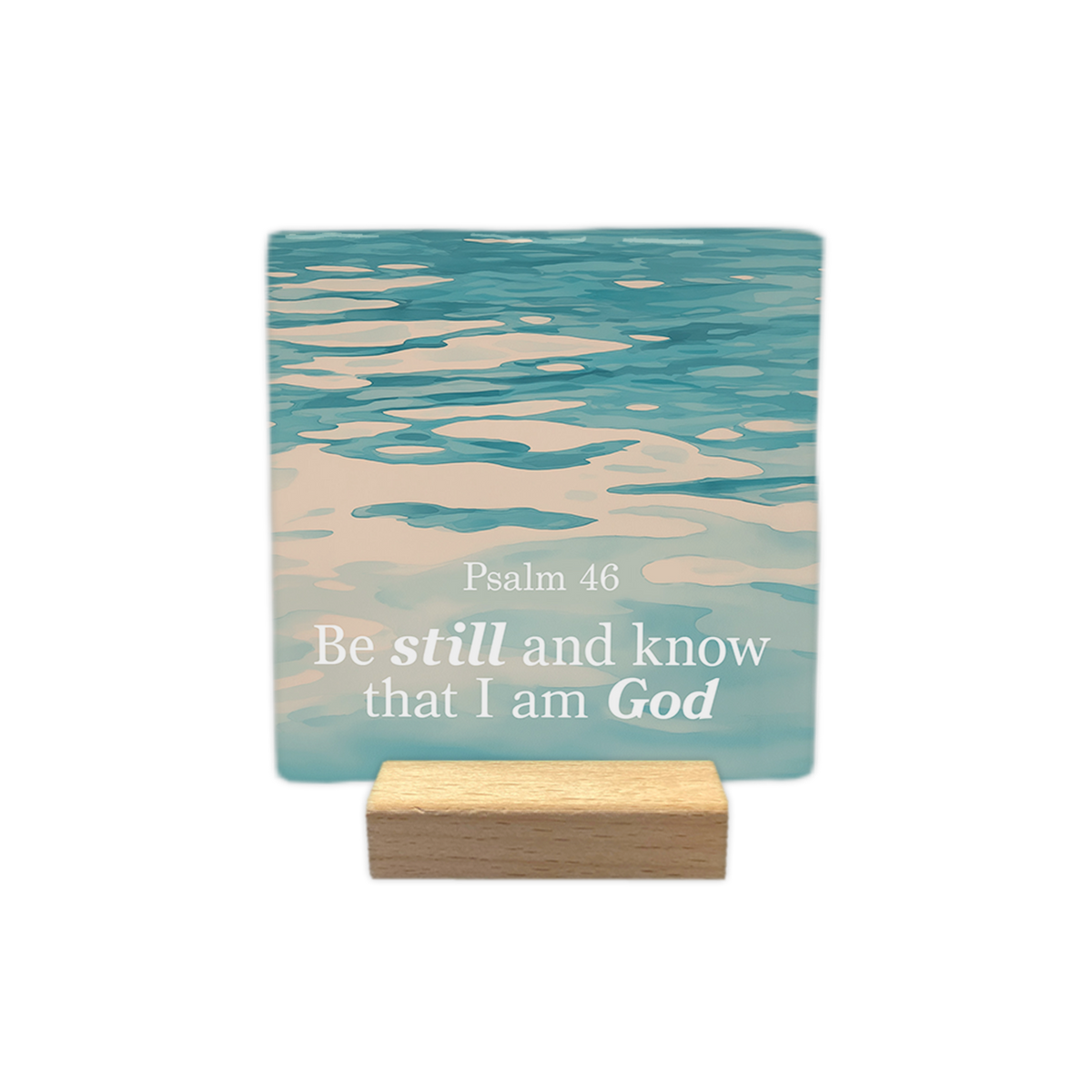 Psalm 46 - Decoratie tegel - Formaat: - Op deze decoratie tegel staat de tekst "Psalm 46" met daaronder "Be still and know that I am God" in witte letters. De woorden "still" en "God" zijn daarbij in een andere stijl weergegeven. De achtergrond toont een foto van kabbelend, blauwachtig water. - Snelwenskaart