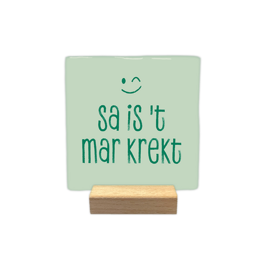 Sa is 't mar krekt - Decoratie tegel - Formaat: - Op deze decoratie tegel staat de tekst "sa is 't mar krekt" in groene letters afgebeeld. Boven de tekst is een groen knipogend gezichtje getekend. De achtergrond van de tegel is lichtgroen van kleur. - Snelwenskaart