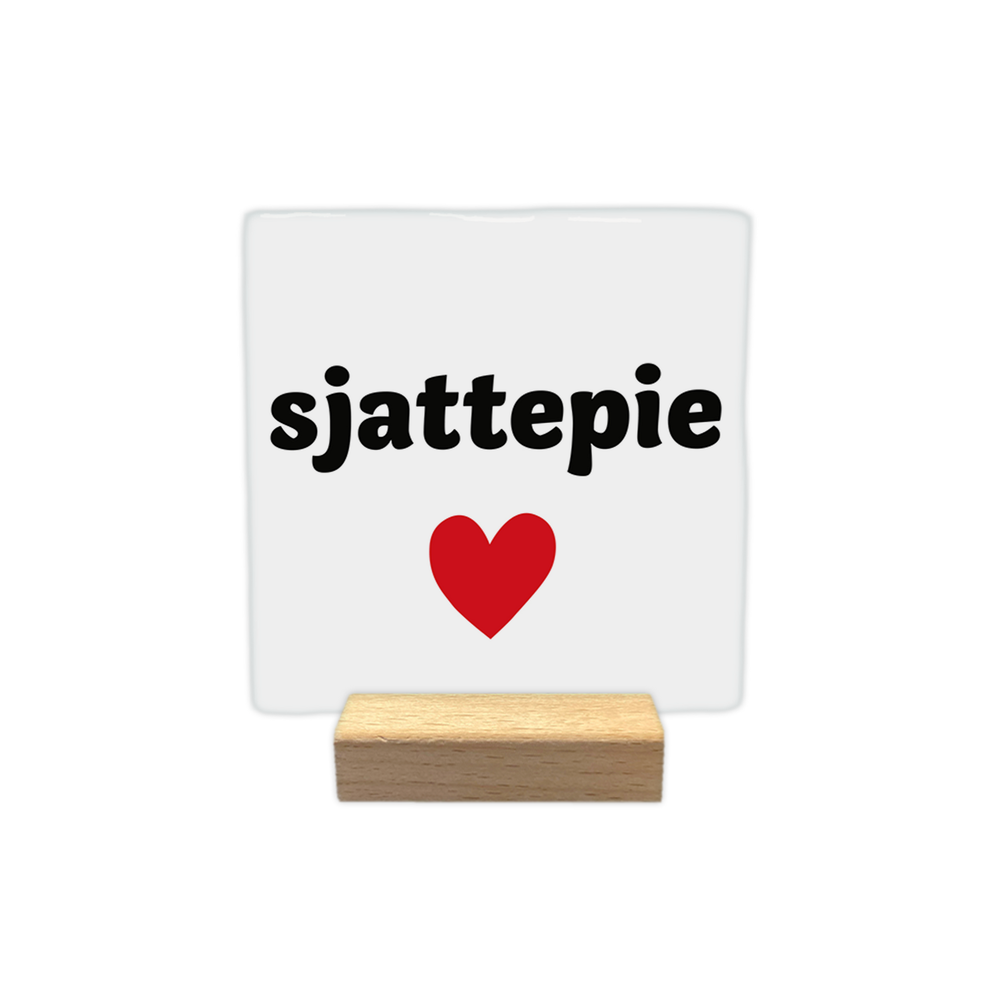 Sjattepie - Decoratie tegel - Formaat: - Op deze decoratie tegel staat de tekst "sjattepie" in zwarte letters tegen een witte achtergrond. Onder de tekst is een rood hart afgebeeld. Het ontwerp is eenvoudig en strak vormgegeven. - Snelwenskaart