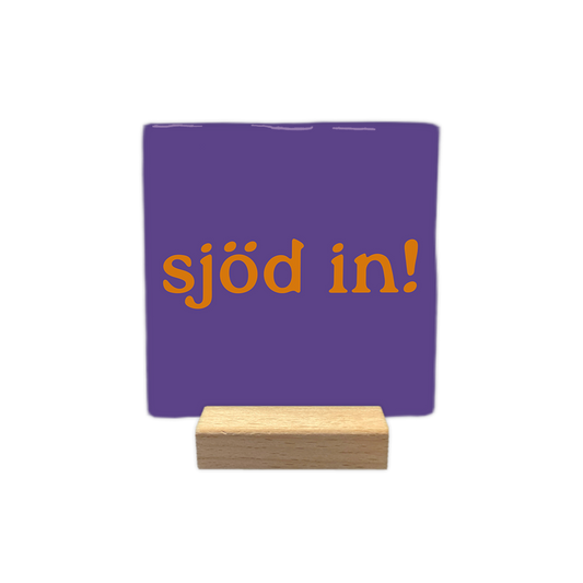 Sjöd in! - Decoratie tegel - Formaat: - Op deze decoratie tegel staat de oranje tekst "sjöd in!" centraal afgebeeld tegen een paarse achtergrond. Het ontwerp is eenvoudig en strak vormgegeven. - Snelwenskaart