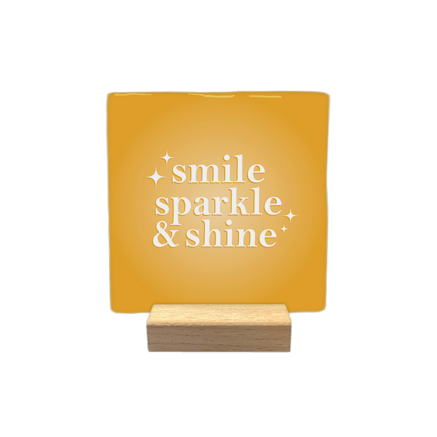 Smile sparkle & shine - Decoratie tegel - Formaat: - Op deze decoratietegel staat de tekst "smile sparkle & shine" in witte letters met een schreeflettertype. De tekst is gecentreerd op een goudgele, vierkante achtergrond en wordt aan weerszijden vergezeld door kleine, gestileerde sterretjes. - Snelwenskaart