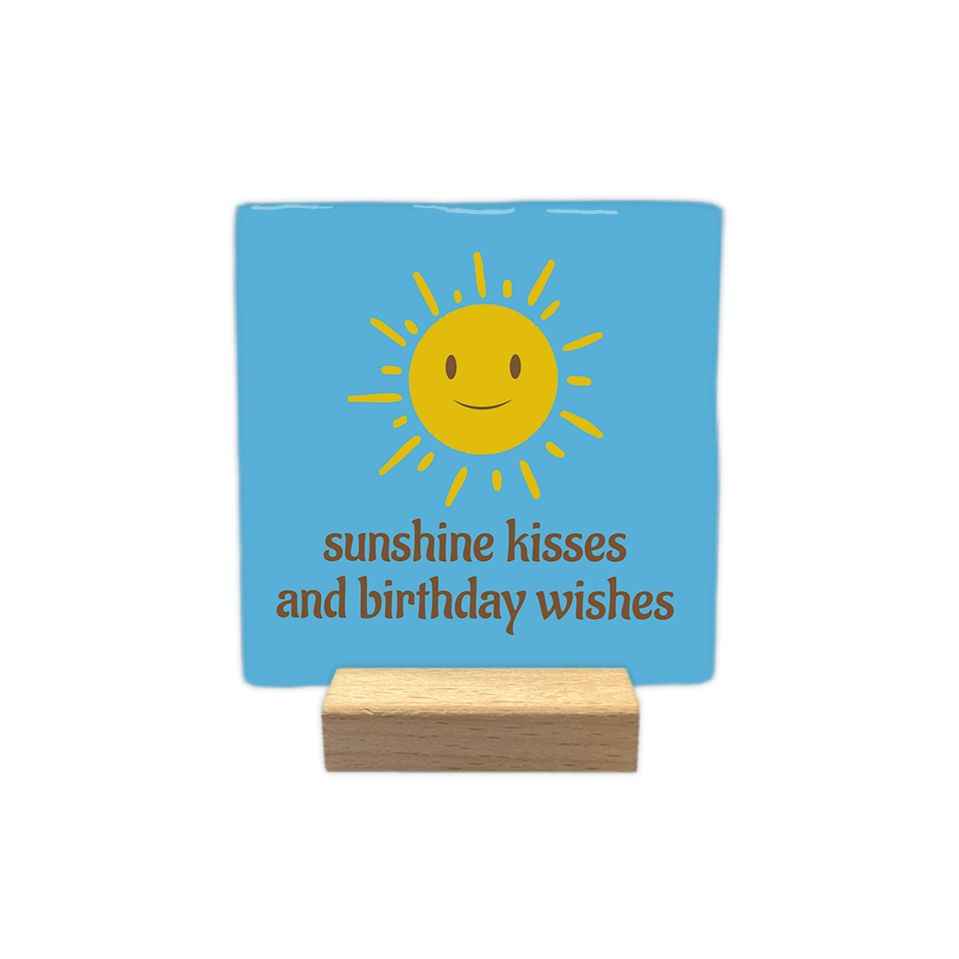 Sunshine kisses and birthday wishes - Decoratie tegel - Formaat: - Op deze decoratie tegel staat in het bruin de tekst 'Sunshine kisses and birthday wishes'. Boven de tekst staat een gele zon met gezicht. De achtergrond van de decoratie tegel is blauw. - Snelwenskaart