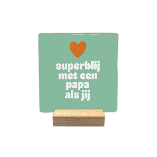Superblij met een papa als jij - Decoratie tegel - Formaat: - Op deze decoratie tegel staat bovenaan een oranje hartje afgebeeld tegen een zachtgroene achtergrond. Daaronder is de tekst "superblij met een papa als jij" in witte, afgeronde letters gecentreerd weergegeven. - Snelwenskaart