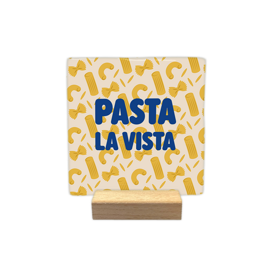 Een uniek decoratief item dat impact maakt in iedere ruimte Op deze decoratie tegel zie je vier verschillende pasta soorten. In het midden van de tegel staat in het blauw de tekst 'Pasta la vista'. Iedere tegel wordt geleverd inclusief houten presentatieblok. 