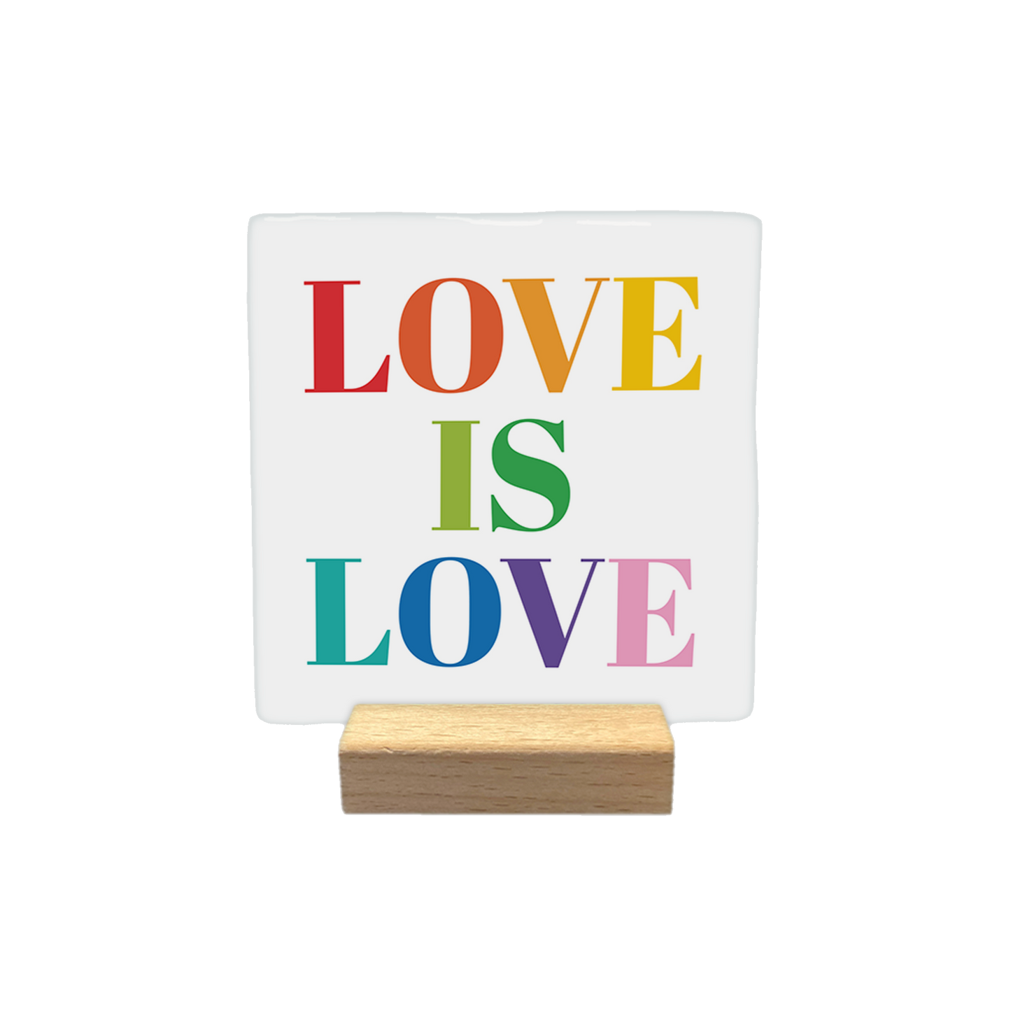 Decoratietegel – 10 x 10 cm - Op deze decoratietegel staat de tekst "LOVE IS LOVE" in een groot schreeflettertype. Elk van de letters is uitgevoerd in een andere kleur van de regenboog, waaronder rood, oranje, geel, groen, blauw, paars en roze.