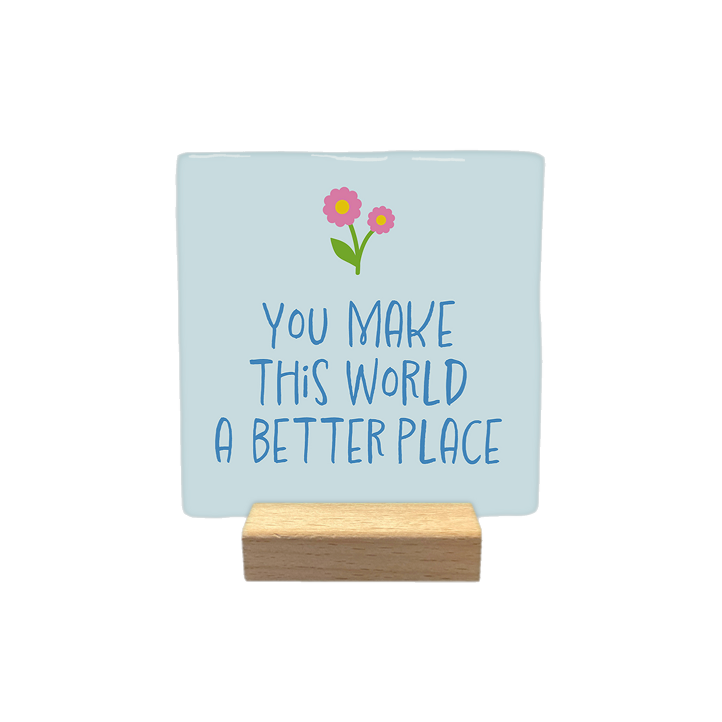 Decoratietegel – 10 x 10 cm - Op deze decoratietegel staat de tekst 'You make this world a better place' geschreven in donderblauwe letters. Boven de tekst staan twee bloemen in de kleur roze met een gele knop en een groen blaadje. De tekst staat gecentreerd op een lichtblauwe achtergrond. 