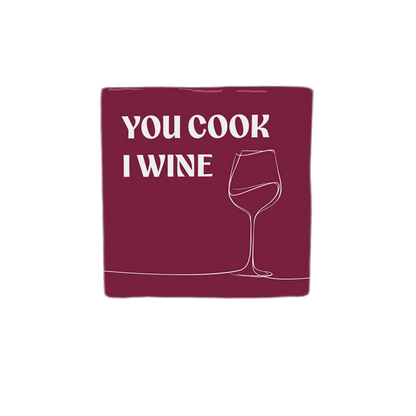 Decoratietegel – 10 x 10 cm - Op deze decoratietegel staat de tekst "YOU COOK I WINE" in witte hoofdletters. Aan de rechterkant is een minimalistische lijntekening van een wijnglas afgebeeld. De tekst en de tekening staan op een dieprode achtergrond. 