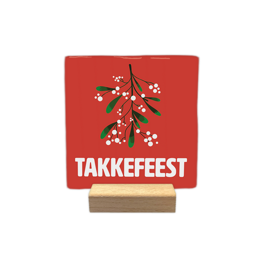 Takkefeest - Decoratie tegel - Formaat: - Op deze decoratie tegel staat een rode achtergrond met een illustratie van een takje maretak met groene bladeren en witte bessen. Onder de maretak staat in grote witte letters de tekst takkefeest. - Snelwenskaart