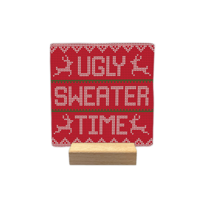 Ugly sweater time - Decoratie tegel - Formaat: - Op deze decoratie tegel staat een rood gebreid patroon dat lijkt op een kersttrui. Het ontwerp heeft witte gebreide patronen, rendieren en strepen in groen en wit. In het midden staat de tekst ugly sweater time in witte gebreide letters. - Snelwenskaart