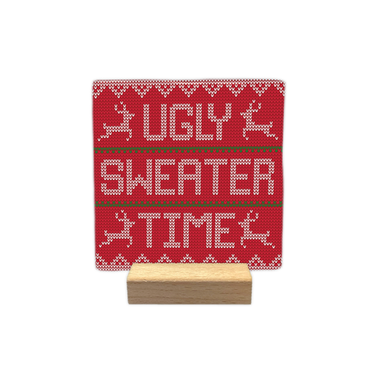 Ugly sweater time - Decoratie tegel - Formaat: - Op deze decoratie tegel staat een rood gebreid patroon dat lijkt op een kersttrui. Het ontwerp heeft witte gebreide patronen, rendieren en strepen in groen en wit. In het midden staat de tekst ugly sweater time in witte gebreide letters. - Snelwenskaart