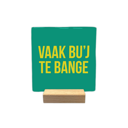Vaak bu'j te bang - Decoratie tegel - Formaat: - Op deze decoratie tegel staat de tekst "vaak bu’j te bang" in gele letters centraal afgebeeld. De achtergrond van de tegel is groen van kleur. - Snelwenskaart
