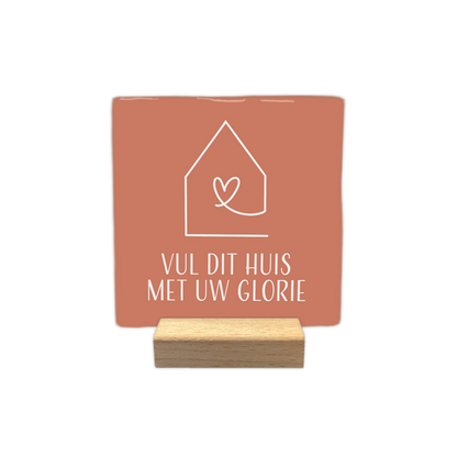 Vul dit huis met uw glorie - Decoratie tegel - Formaat: - Op deze decoratie tegel staat een wit lijnontwerp van een huisje met een hartje in het midden. Daaronder staat de tekst "Vul dit huis met uw glorie" in witte letters. Het geheel is geplaatst tegen een terracottakleurige achtergrond. - Snelwenskaart