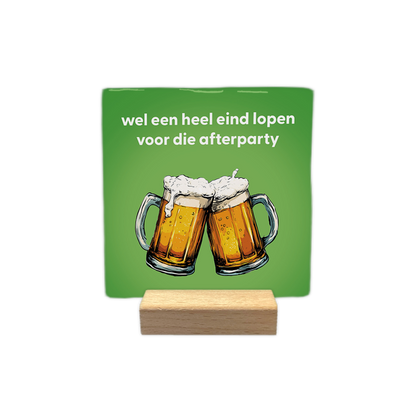 Wel een heel eind lopen - Decoratie tegel - Formaat: - Op deze decoratie tegel staat bovenaan de tekst "wel een heel eind lopen voor die afterparty" in witte letters. Daaronder zijn twee glazen bier te zien die tegen elkaar aan worden gehouden. De achtergrond heeft een egale groene kleur. - Snelwenskaart