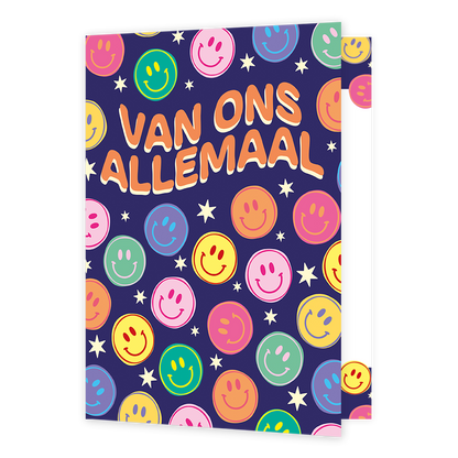 Op deze wenskaart staat de tekst "VAN ONS ALLEMAAL" in grote, oranje letters met een beige omlijning tegen een donkerblauwe achtergrond. De illustratie is bezaaid met talloze lachende smileys in diverse kleuren zoals roze, geel, groen, oranje en blauw. Tussen de smileys door zijn kleine witte sterretjes getekend die over het hele oppervlak verspreid zijn.