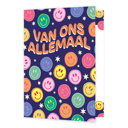 Op deze wenskaart staat de tekst "VAN ONS ALLEMAAL" in grote, oranje letters met een beige omlijning tegen een donkerblauwe achtergrond. De illustratie is bezaaid met talloze lachende smileys in diverse kleuren zoals roze, geel, groen, oranje en blauw. Tussen de smileys door zijn kleine witte sterretjes getekend die over het hele oppervlak verspreid zijn.