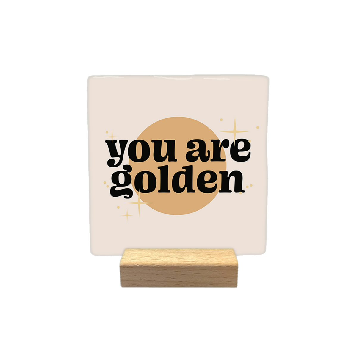 You are golden - Decoratie tegel - Formaat: - Op deze decoratietegel staat de tekst "you are golden" in zwarte letters met een afgerond, speels lettertype. De tekst is gecentreerd over een goudkleurige cirkel en wordt omringd door kleine, gestileerde sterretjes. Het gehele ontwerp bevindt zich op een crèmekleurige achtergrond. - Snelwenskaart