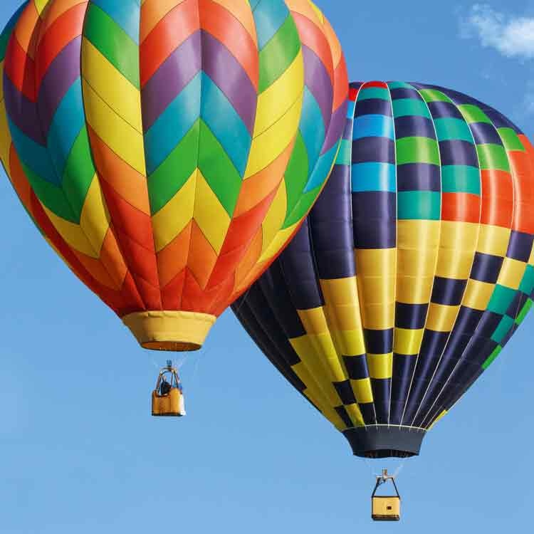 Op deze wenskaart staat een foto van twee luchtballonnen die in de lucht vliegen.