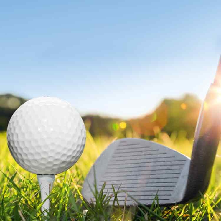 Op deze wenskaart staat foto van een golfclub en een golfbal in het gras.