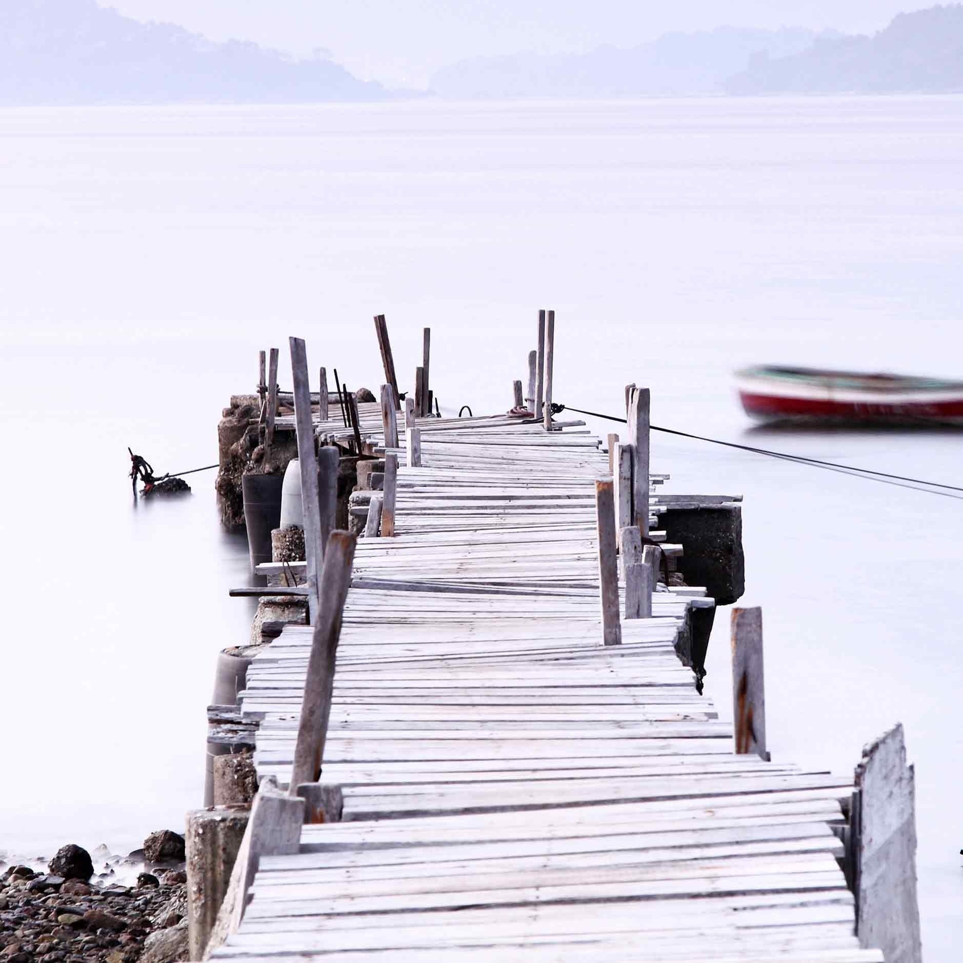 Op deze wenskaart staat een foto van een steiger die uitloopt op een meer.