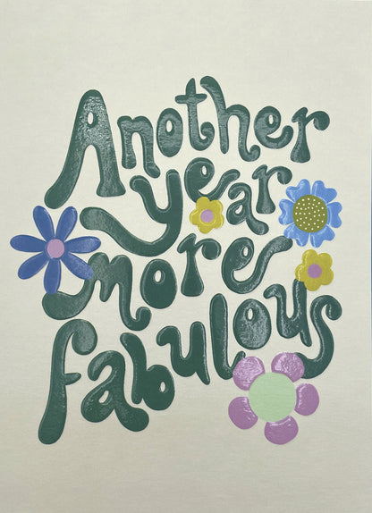 Op deze wenskaart staat de tekst: "Another year moren fabulous" omringt door bloemen.