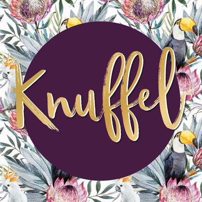 Op deze wenskaart staan roze bloemen met groene bladeren en witte en zwarte vogels. In het midden staat een paarse cirkel met de tekst: "Knuffel".