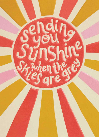 Op deze wenskaart staan lijnen in de kleuren roze, wit, groen en oranje met in het midden een rode cirkel met de tekst: "Sending you sunshine when the skies are grey".