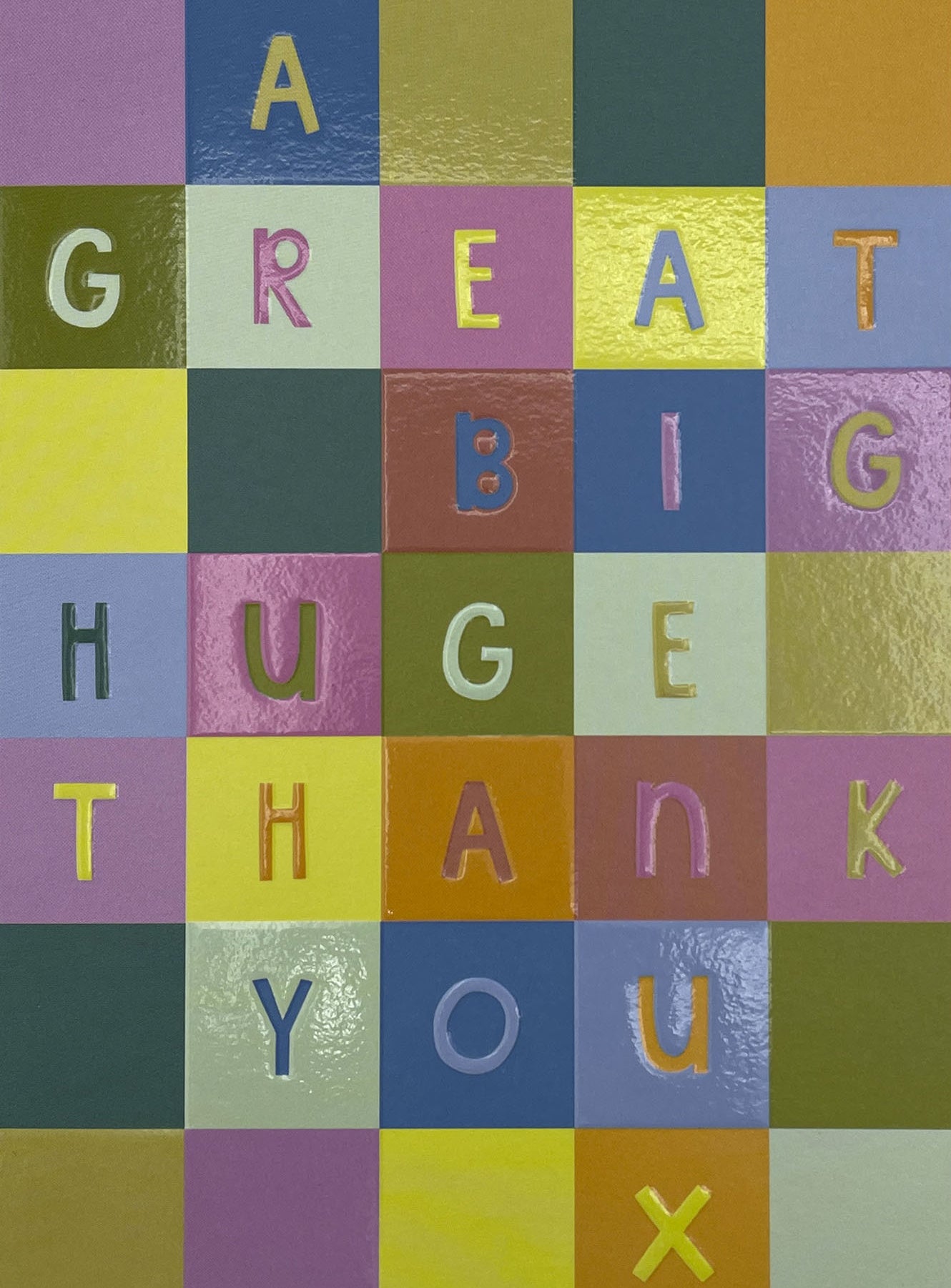 Op deze wenskaart staan vakjes in de kleuren paars, groen, oranje, geel, rood en blauw. In de vakjes staan letters die de tekst: "A great big hug thank you x" vormen. 