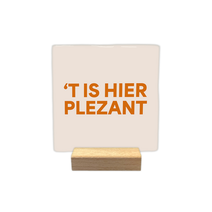 t is hier plezant - Decoratie tegel - Formaat: - Op deze decoratie tegel staat de tekst "'t is hier plezant" in oranje letters. De achtergrond van de tegel is lichtbeige. - Snelwenskaart