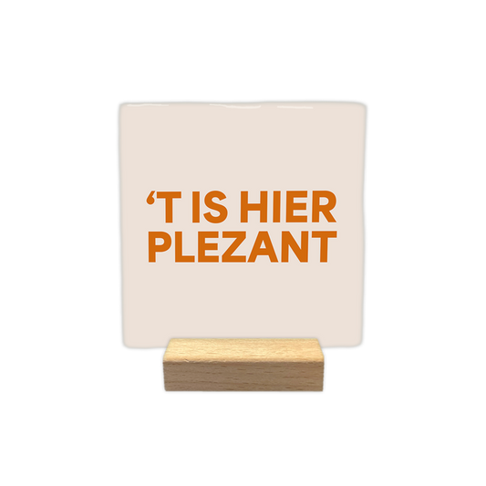 t is hier plezant - Decoratie tegel - Formaat: - Op deze decoratie tegel staat de tekst "'t is hier plezant" in oranje letters. De achtergrond van de tegel is lichtbeige. - Snelwenskaart